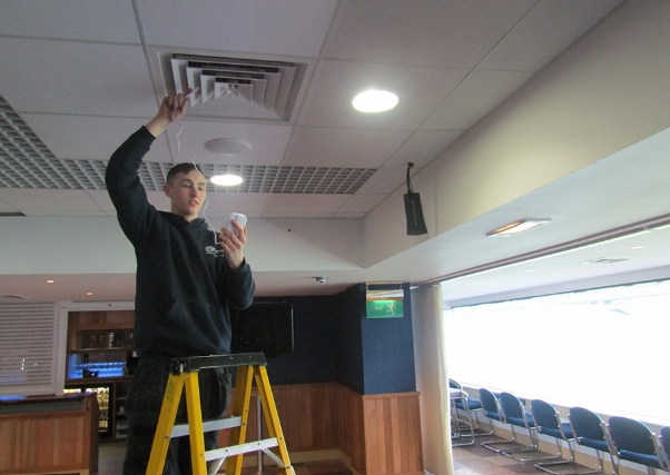 Universal Cooling engineer servicing a ceiling cassette air conditioning unit on site.